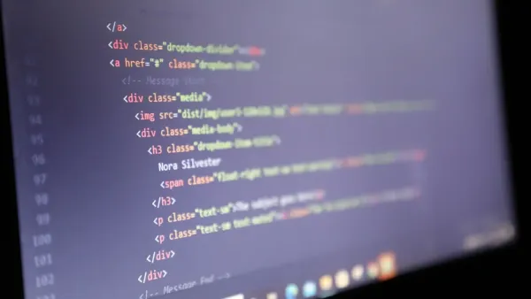 Código HTML iluminado que se muestra en la pantalla de una computadora, vista de cerca.