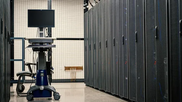 Contemporary computer on support between telecommunication racks and cabinets in modern data center