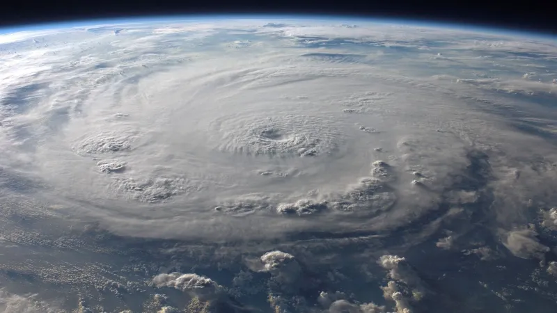 A stunning aerial view of Earth with a massive swirling hurricane, highlighting meteorological beauty.