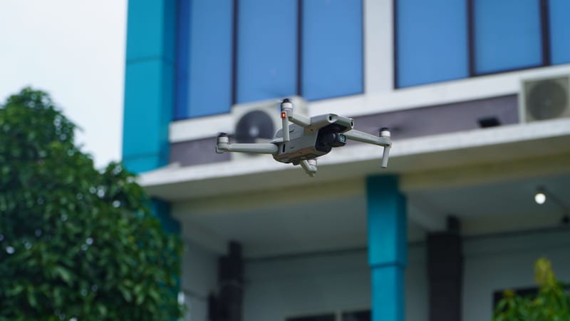 Aerial view of a drone flying near a modern building in Indonesia.
