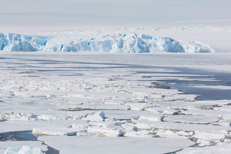 A breathtaking view of a frozen sea with icebergs and snow-covered surfaces, showcasing winter's chill.