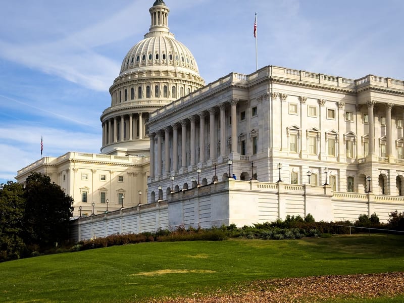 A picturesque view of the US Capitol Building in Washington, DC, under a clear sky.
