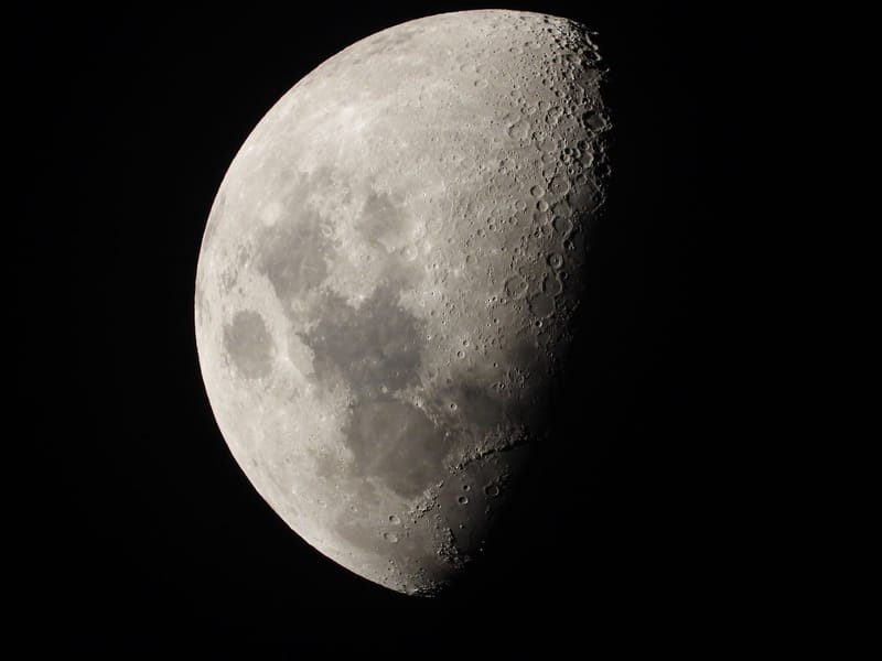 Detailed close-up of the moon's surface in the first quarter phase, showcasing craters and textures.