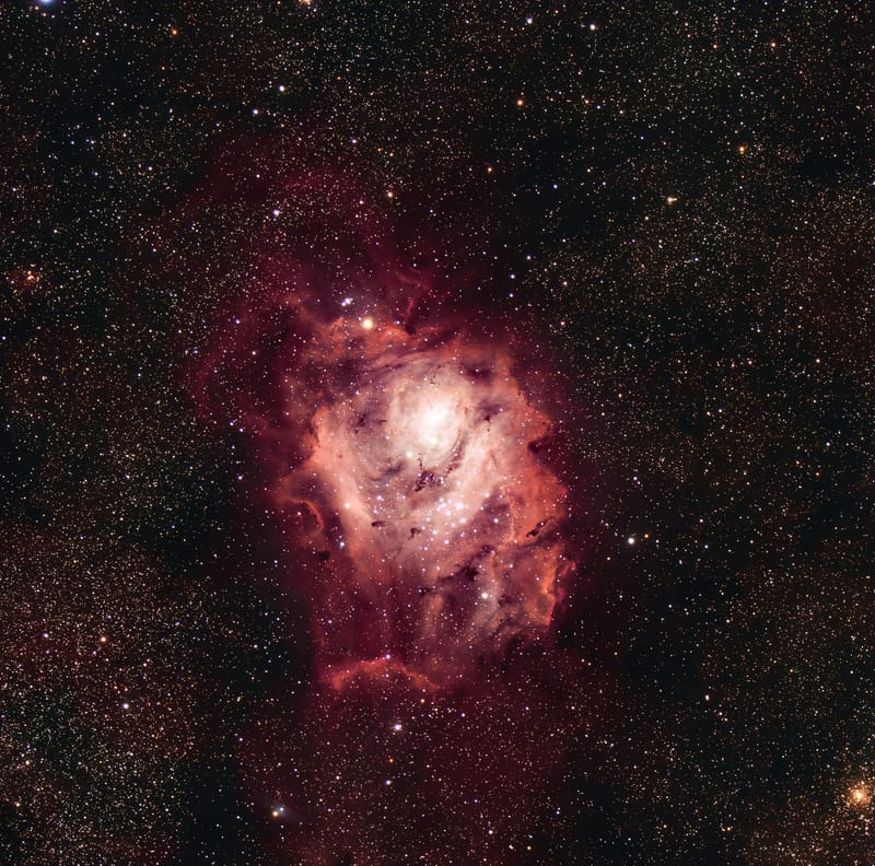 Explore the vibrant colors and details of a nebula surrounded by a sea of twinkling stars.