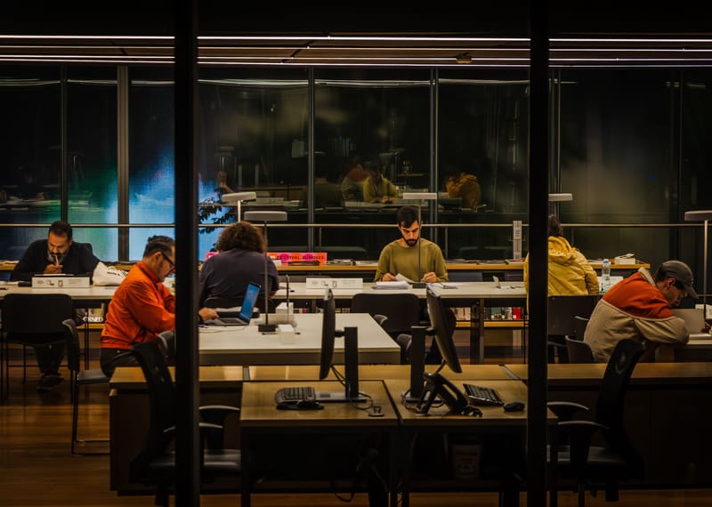 Students focused on studying in a modern São Paulo library at night.