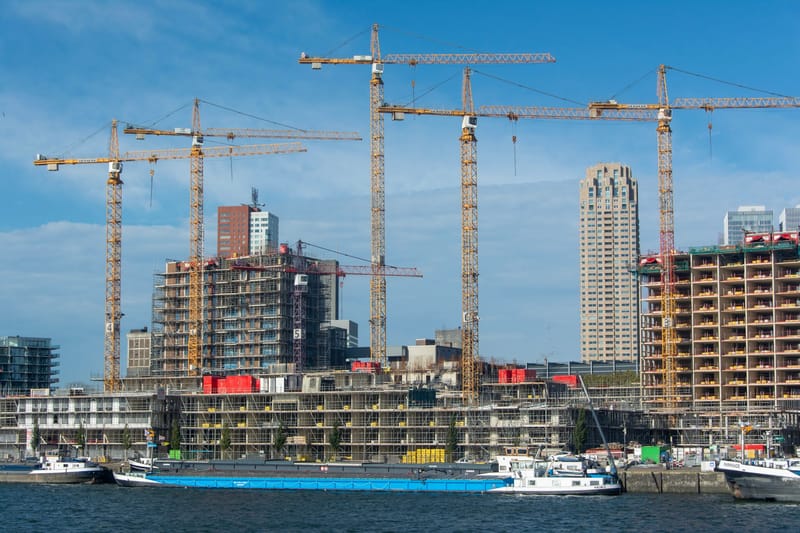 A modern construction site with multiple cranes and buildings in progress.