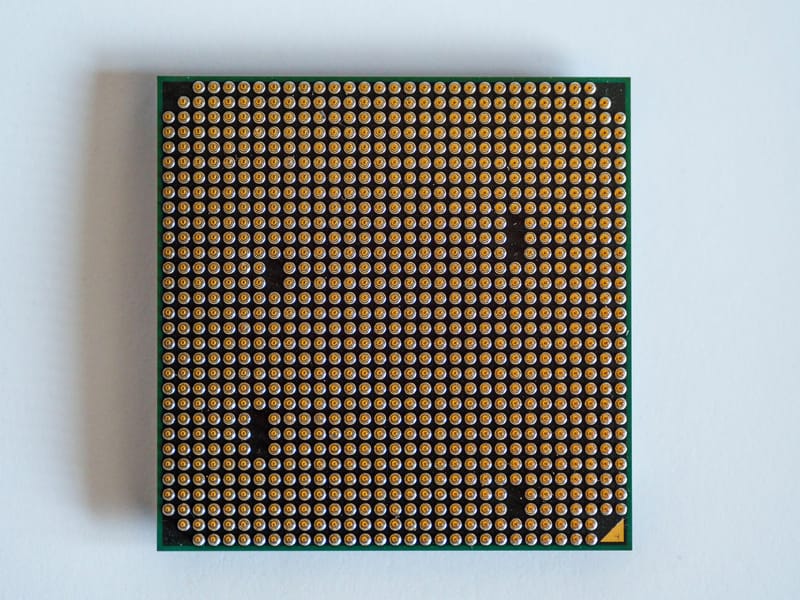 Detailed view of a computer processor, showcasing its pins, against a clean white backdrop.