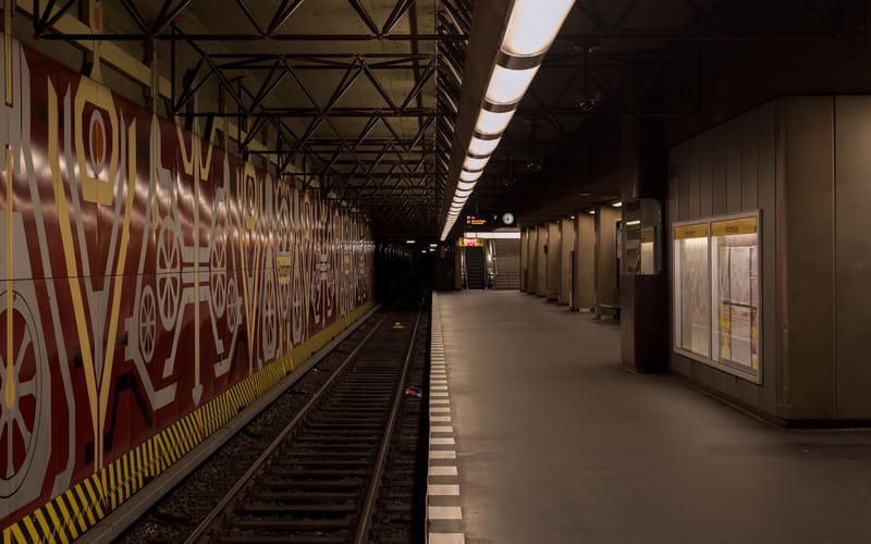 A deserted subway platform in Berlin at night, showcasing urban architecture.