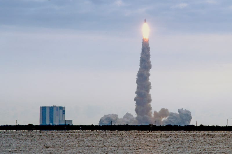 Dramatic view of a rocket launching from Kennedy Space Center in Florida with a trail of smoke.