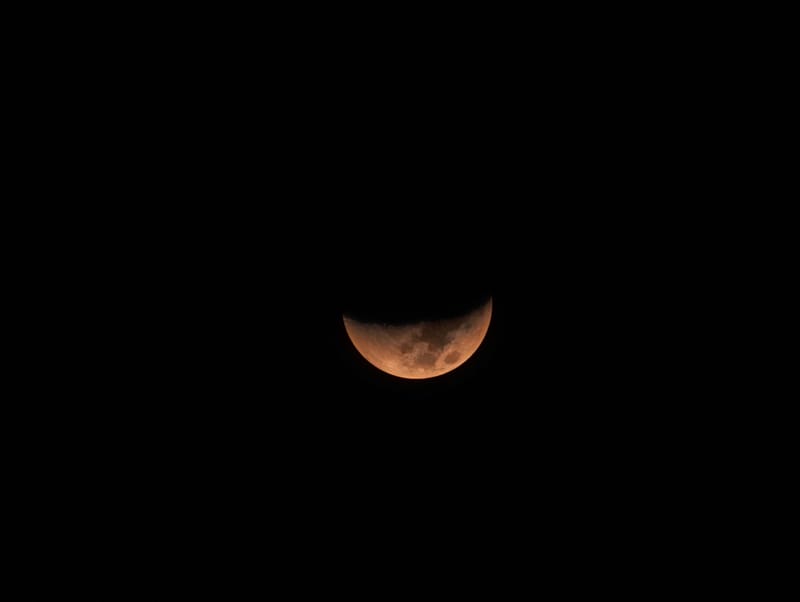 Captivating image of a partial lunar eclipse against a black sky, showcasing the moon's surface.