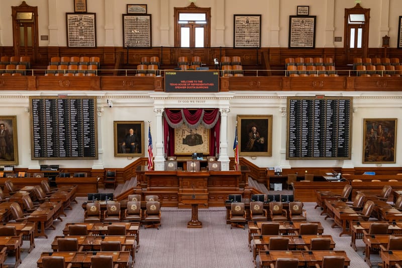 The Texas House of Representatives chamber, featuring legislative seats and historical portraits.