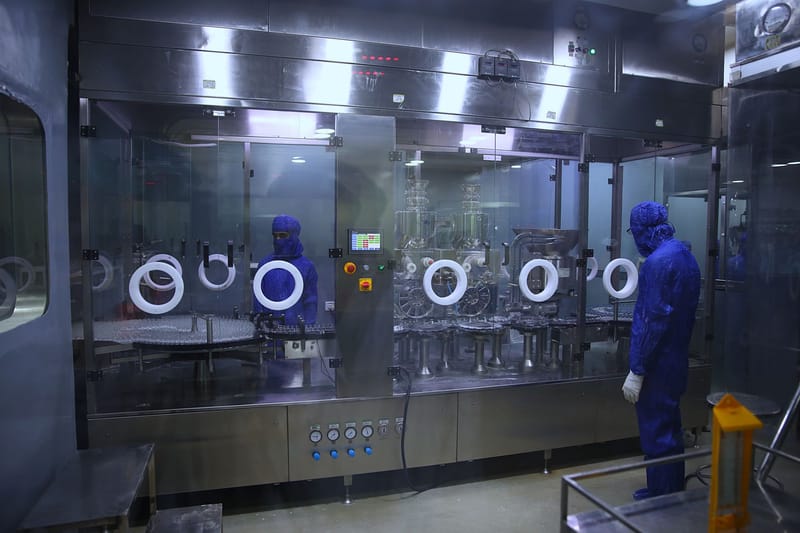 Workers in protective gear inside a sterile pharmaceutical manufacturing plant in Rawalpindi, Pakistan.