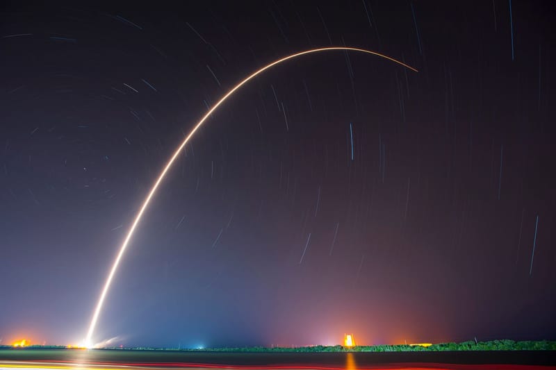 A breathtaking shot of a rocket launch, creating a vivid trail under a starry night sky.