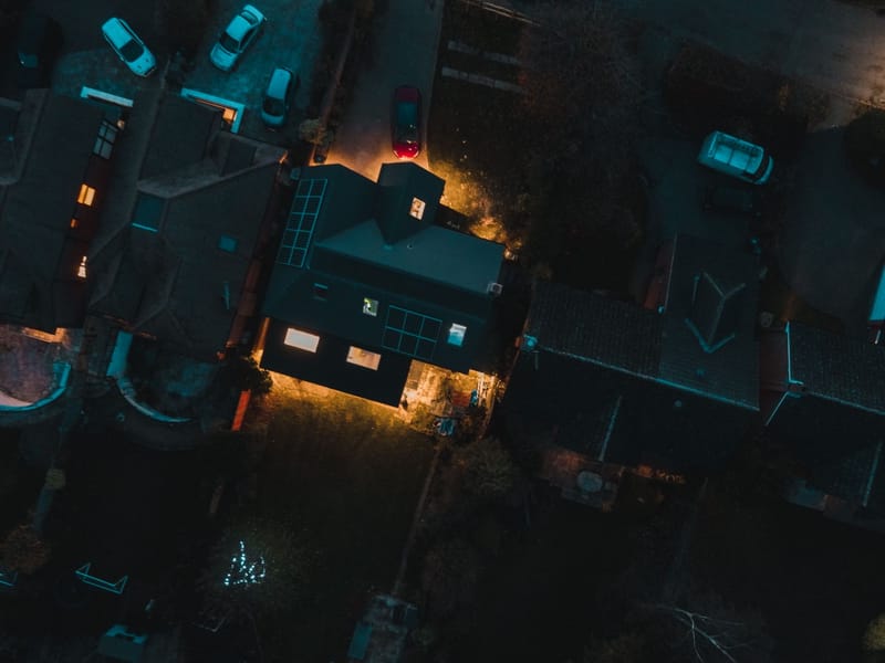 Drone view of roof of traditional houses located in city residential district in evening