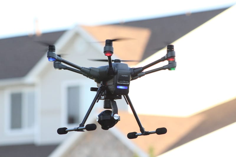 A drone flying in a suburban area, capturing aerial views of a residential neighborhood.