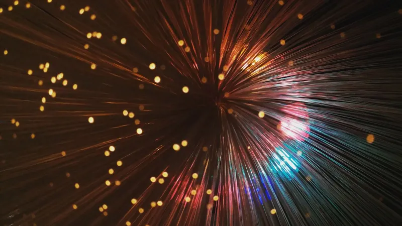 From below of abstract backdrop representing many thin colorful vertical lines shining near small spots on black background