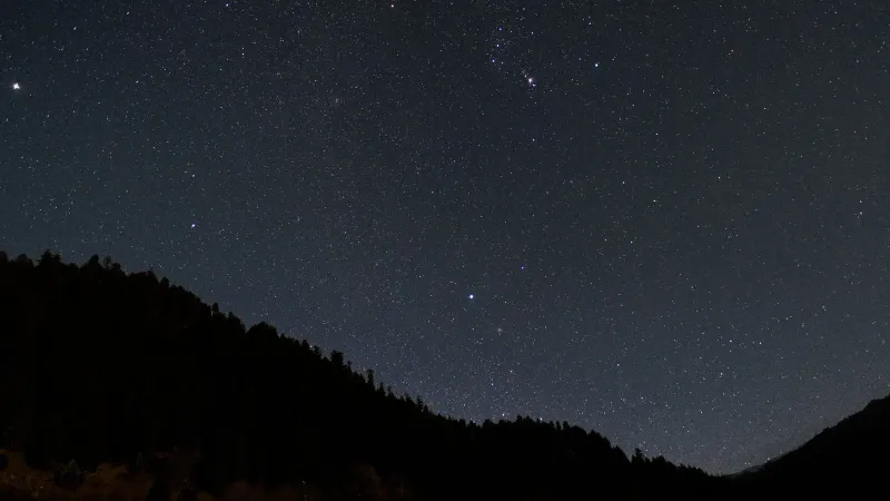 A breathtaking view of a star-filled night sky above silhouetted mountains, perfect for astronomy enthusiasts.