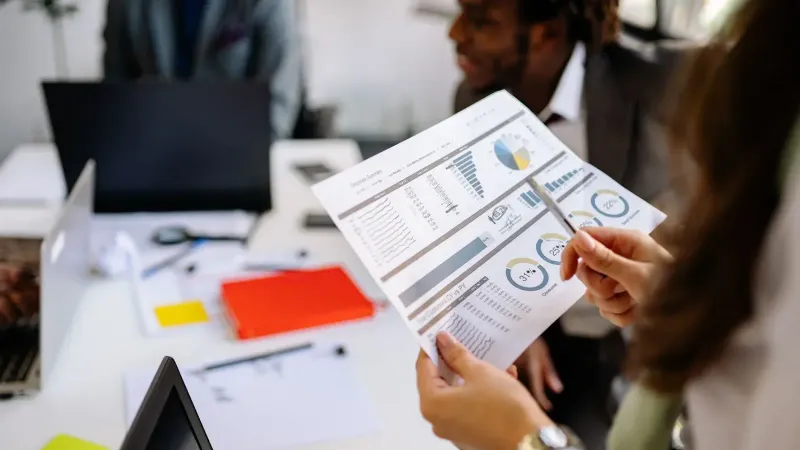 Professionals reviewing business charts and documents in a team meeting.