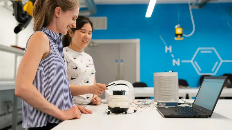 Dos ingenieras que trabajan en investigación y desarrollo en un moderno laboratorio.