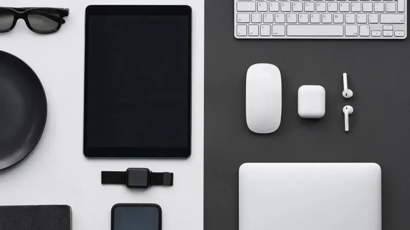 Stylish flatlay of modern tech gadgets including tablet, smartphone, smartwatch, and accessories.