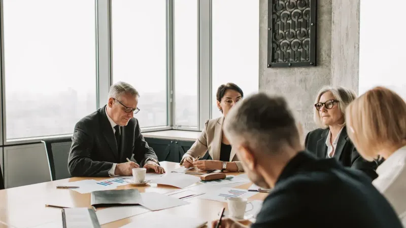 Business professionals engaged in a collaborative meeting around a conference table.