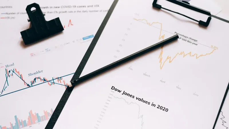 Clipboard with stock market charts and graphs representing financial data analysis.