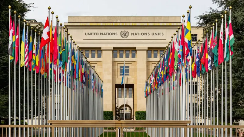 View of the United Nations Office in Geneva adorned with flags of various countries.