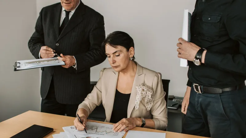 Business professionals collaborating on financial documents in an office setting.