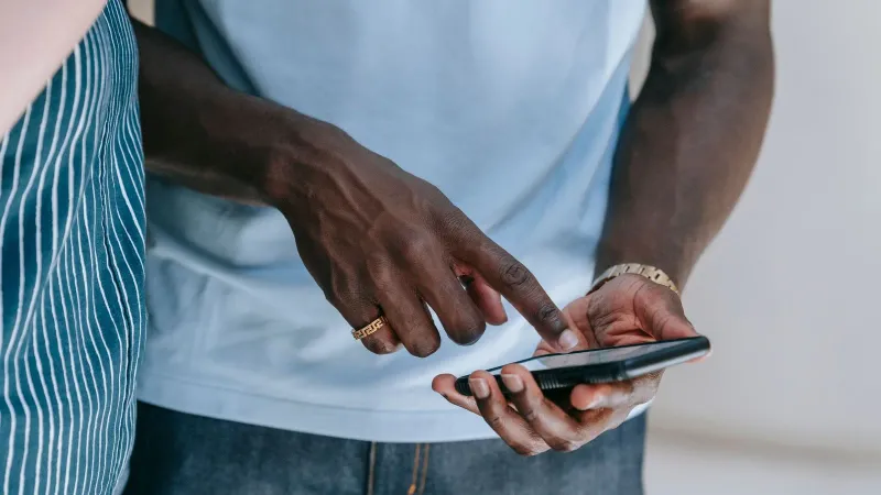 Close-up of a person interacting with a smartphone, captured indoors in a casual setting.