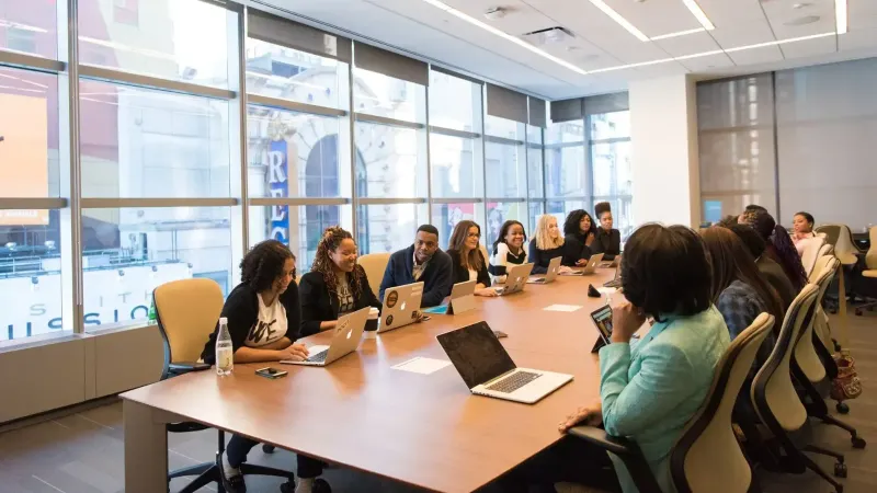 A diverse team of business professionals collaborating in a modern meeting room.