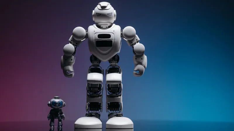 Close-up shot of two white robots displayed on a colorful gradient background symbolizing innovation in robotics.