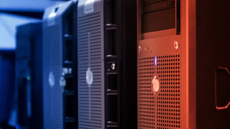 Close-up of tower servers in a data center with blue and red lighting.