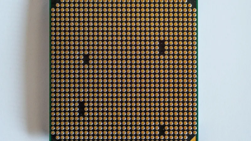 Detailed view of a computer processor, showcasing its pins, against a clean white backdrop.