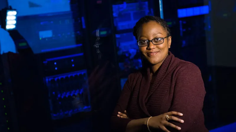 Confident woman in data center, showcasing tech expertise.