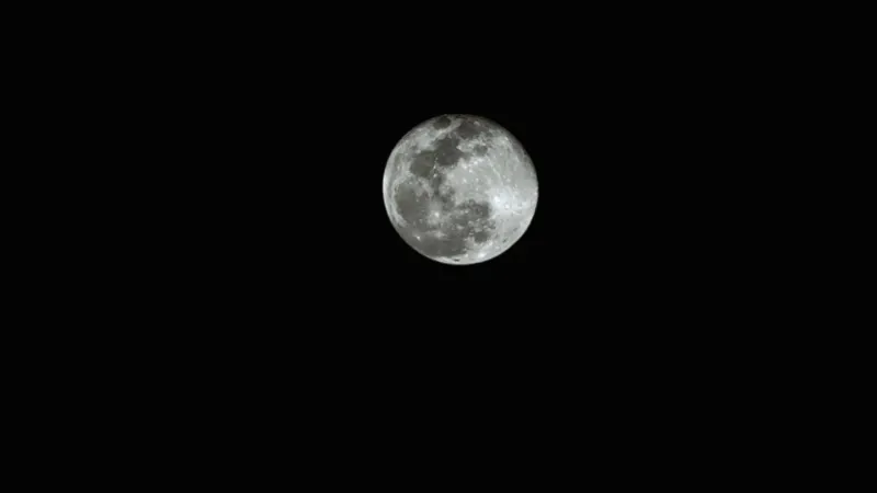 High-resolution black and white capture of the full moon against a dark night sky.
