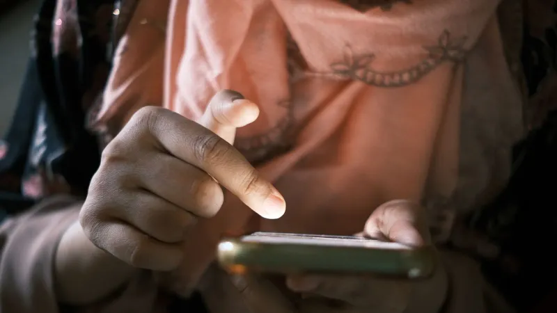 Close-up of hands using a smartphone indoors, highlighting touch technology.