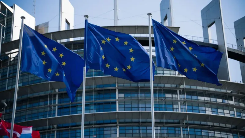 European Union flags waving outside the European Parliament in Strasbourg.