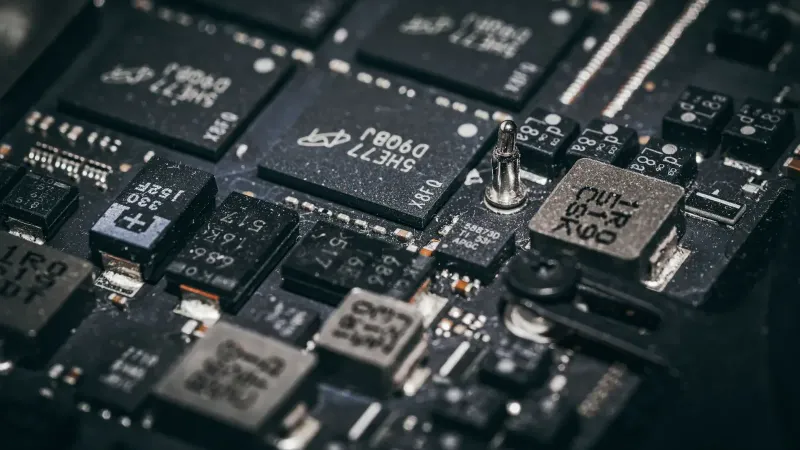 Detailed close-up of electronic microchips on a circuit board, showcasing technology and engineering intricacies.