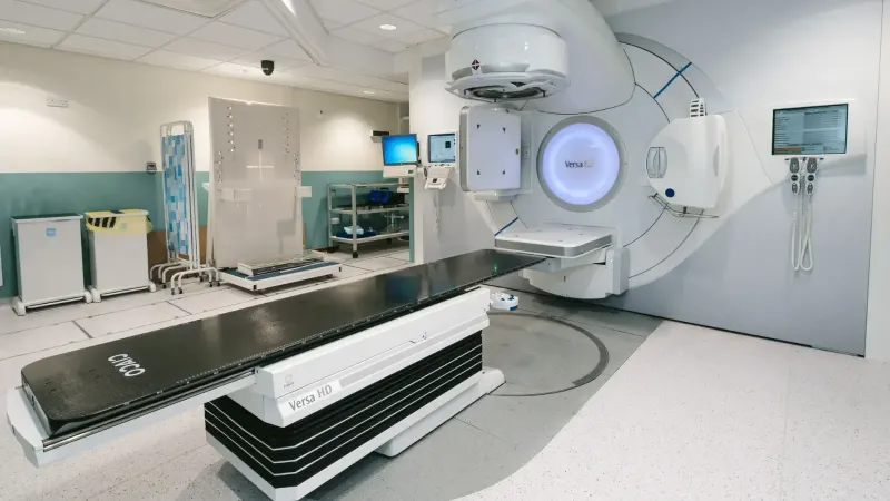 High-tech radiotherapy machine in a hospital's clinical setting for patient treatment.