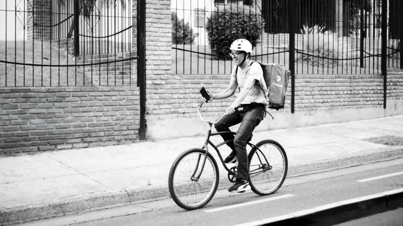Black and white photo of a bicyclist in Buenos Aires, showcasing urban lifestyle.