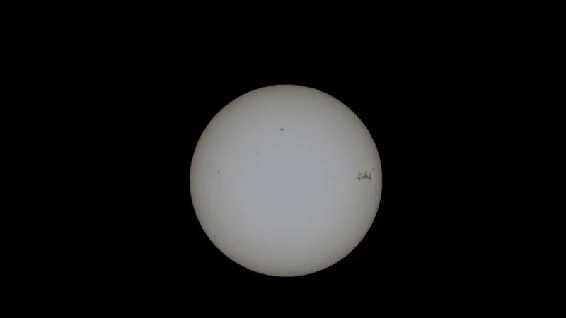 Close-up image of the sun with visible sunspots on a black background.