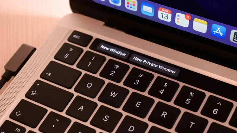 A detailed view of a laptop keyboard with browser tabs open, highlighting 'New Window' and 'New Private Window'.