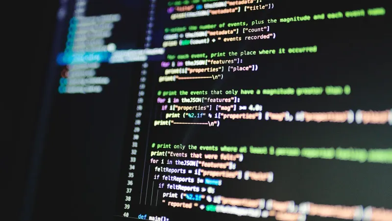 Close-up of colorful programming code displayed on a computer monitor with a dark background.