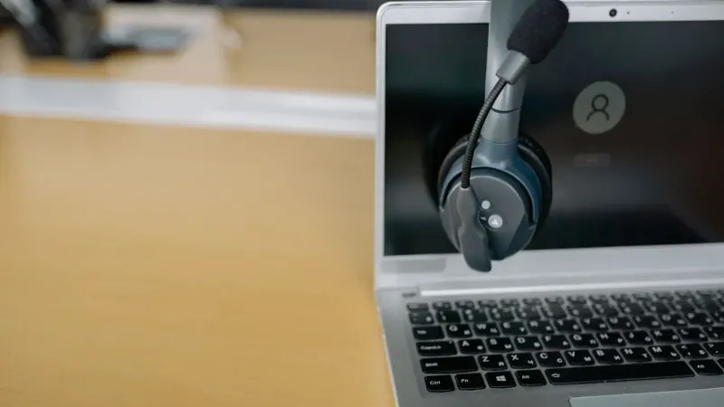 Close-up of wireless headset on laptop screen, ideal for communication tech visuals.