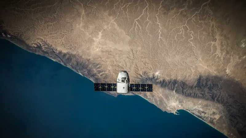 A satellite hovering above Earth's coastline, captured from space.
