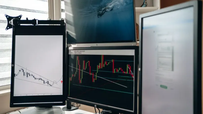 Una configuración de oficina en el hogar con múltiples monitores que muestran gráficos comerciales y análisis de datos.