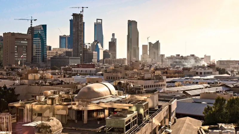 Skyline of Riyadh, Saudi Arabia featuring modern skyscrapers and construction cranes at sunset.