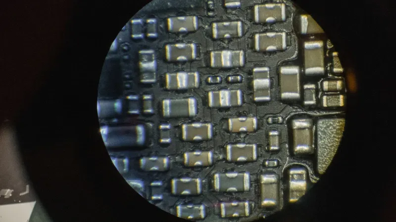 Detailed image of microchip components viewed through a microscope lens.