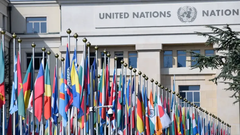 Colorful flags outside the United Nations office in Geneva, symbolizing global unity.