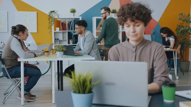 Creative workspace with diverse team collaborating on projects in a modern office setting.